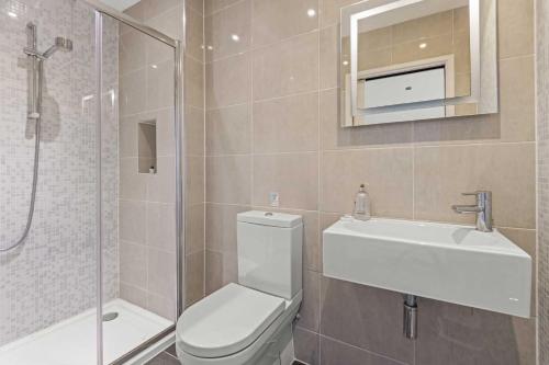 a bathroom with a toilet and a sink and a shower at House 8 in Looe