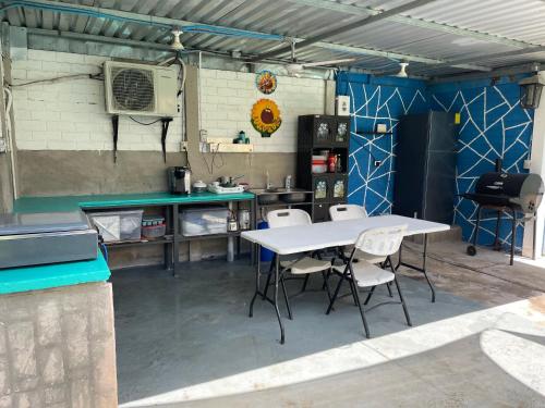 a kitchen with a table and chairs in a garage at RANCHO LA POTRANCA SV in Las Hojas