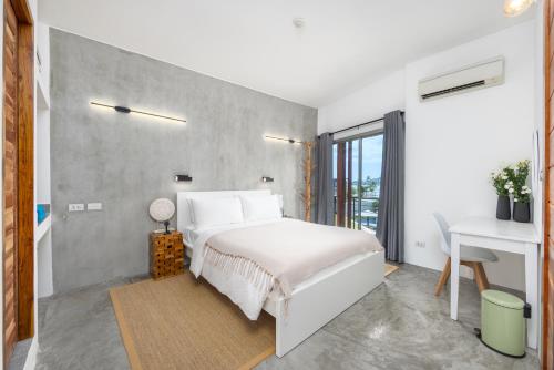 Nathon BayにあるNEW 2 bedrooms condo on Bangrak beachの白いベッドと机のある寝室