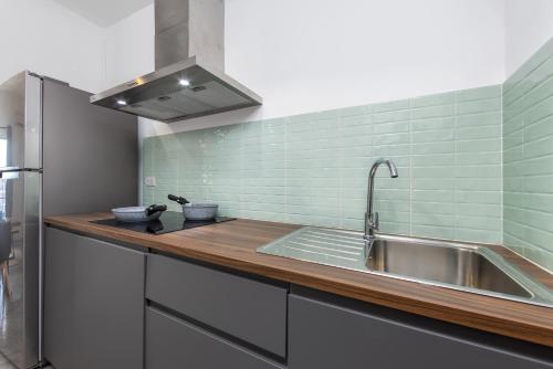 Nathon BayにあるNEW 2 bedrooms condo on Bangrak beachのステンレス製のシンクと緑のタイルが施されたキッチン