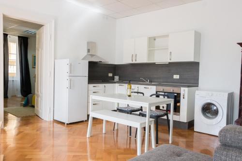 a kitchen with white cabinets and a white table at Sunny Apartment Anamaria Opatija in Opatija