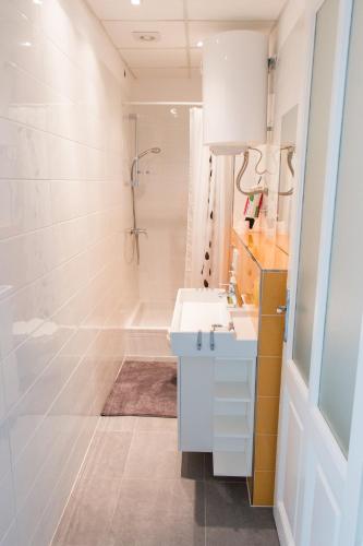 a bathroom with a white sink and a tub at Sunny Apartment Anamaria Opatija in Opatija