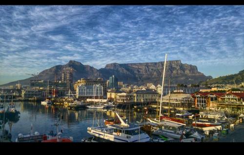 a group of boats in a harbor with a mountain in the background at Seabreeze Summit Retreat Your Perfect Escape in Cape Town
