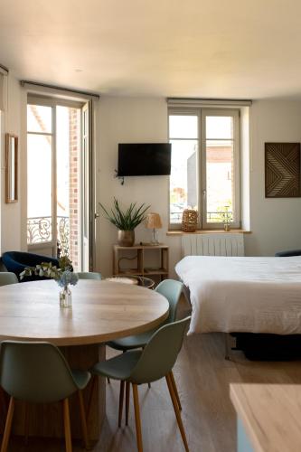 une chambre avec un lit, une table et des chaises dans l'établissement App Marguerite - Villa Bon Accueil proche mer, à Mers-les-Bains