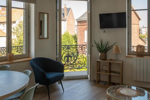 a living room with a view of a balcony at App Marguerite - Villa Bon Accueil proche mer in Mers-les-Bains