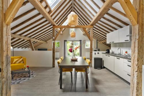 a kitchen and dining room with a wooden ceiling at Boerderijwoning 't Trogje in Heiloo