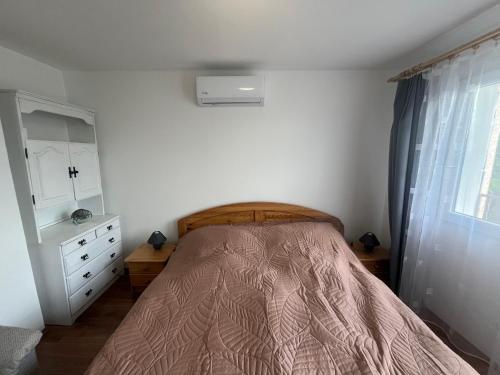 a bedroom with a bed and a dresser and a window at LídRind porta in Zalaszentgrót