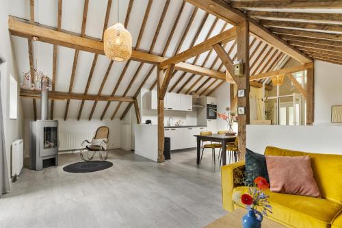 a living room with a yellow couch and a table at Boerderijwoning 't Trogje in Heiloo