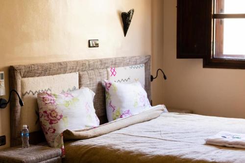 a bedroom with a bed with pink and white pillows at Imlil Oasis - Oasis Dimlil in Imlil