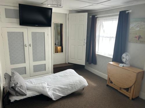 a bedroom with a bed and a flat screen tv at Royal Albion Walton in Walton-on-the-Naze