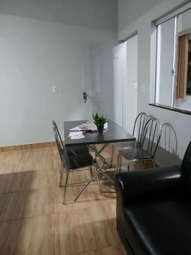 a dining room table and chairs in a living room at Ap de minas in Piumhi