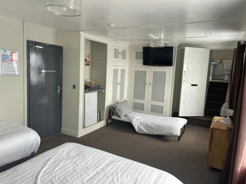 a hotel room with two beds and a television at Royal Albion Walton in Walton-on-the-Naze