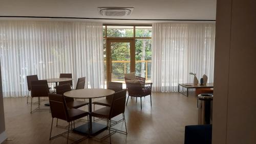 a dining room with tables and chairs and a large window at Novo studio sofisticado ao lado do Allianz Parque in Sao Paulo