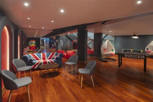a living room with a pool table and chairs at Radisson RED Phuket Patong Beach in Patong Beach