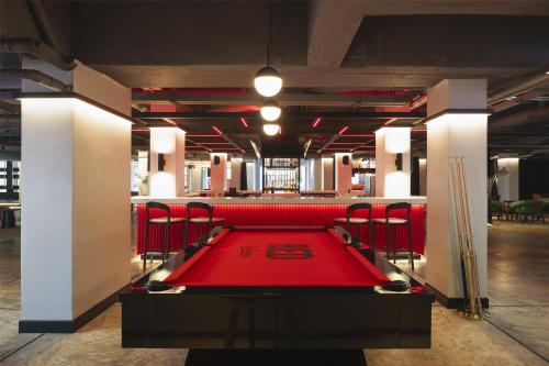 a red pool table in a room with red chairs at Radisson RED Phuket Patong Beach in Patong Beach