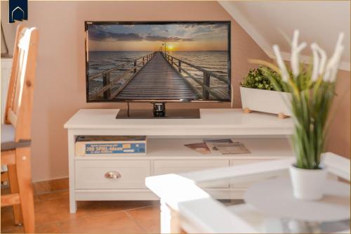 a tv sitting on top of a white dresser at Ferienwohnung Thurbruch in Zirchow