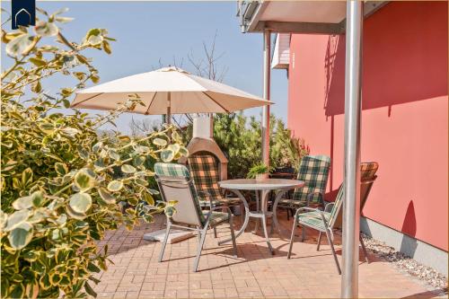 a table and chairs and an umbrella on a patio at Ferienwohnung Thurbruch in Zirchow