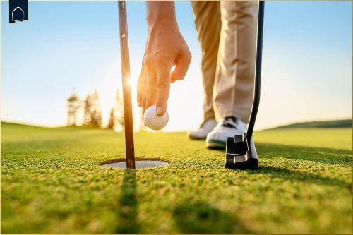 a person holding a golf ball on a golf course at Ferienwohnung Thurbruch in Zirchow
