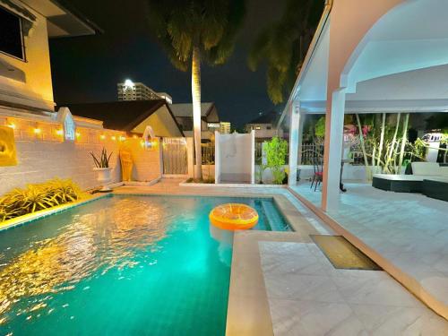 a pool with a frisbee in the water at night at Royal Adobe Pool Villa in Jomtien Beach