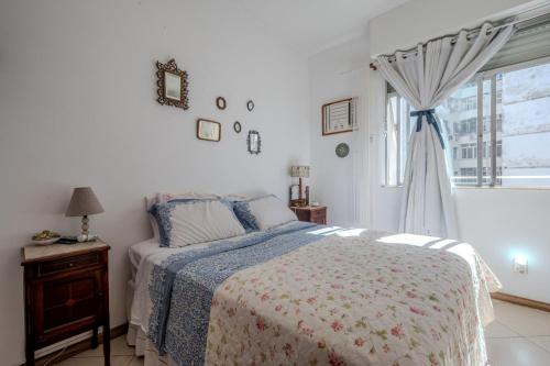 a white bedroom with a bed and a window at 2 quartos a 200m da Praia do Flamengo in Rio de Janeiro