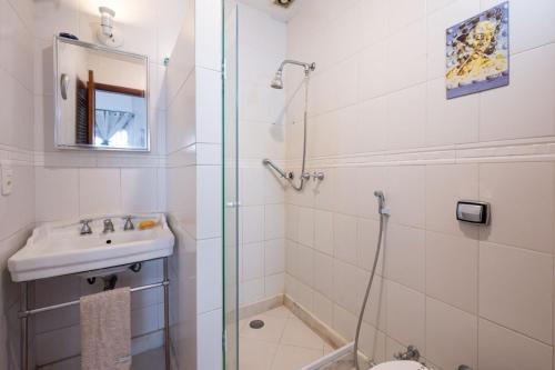 a bathroom with a shower and a sink and a toilet at 2 quartos a 200m da Praia do Flamengo in Rio de Janeiro
