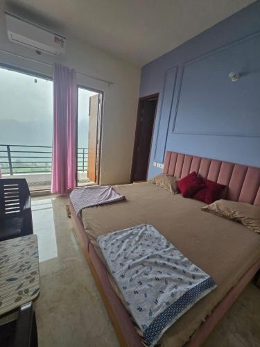 a bedroom with a large bed with a large window at Hotel hr inn morni in Panchkula