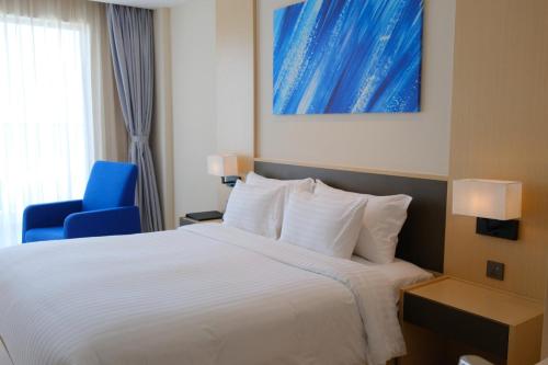 a hotel room with a bed and a blue chair at Modern Beach Apartment - Arena Resort Cam Ranh in Cam Ranh International Airport