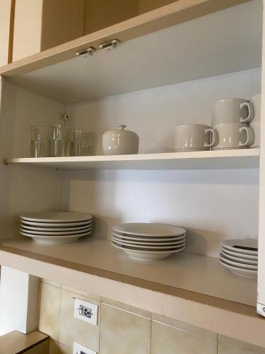 a kitchen shelf with plates and cups on it at Depto 5 pax, 2 baños, Cirrus 967 in Las Lenas