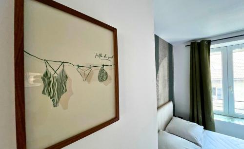 a mirror hanging on a wall in a bedroom at Le Chti nid d'Opale in Boulogne-sur-Mer