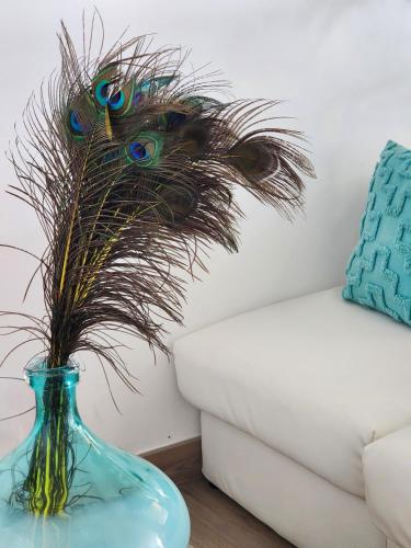 a blue vase with peacock grass in a living room at Hotel Bellariva in Lido di Jesolo