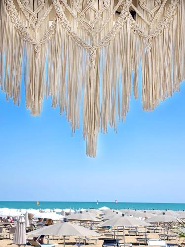 a view of a beach with umbrellas and umbrellas at Hotel Bellariva in Lido di Jesolo