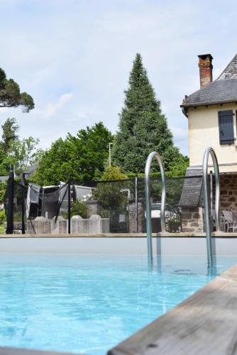 a swimming pool with blue water and metal rails at Ô Retrouvail ' in Cublac