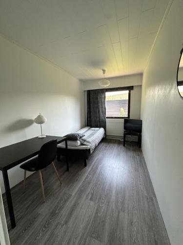 Habitación con cama, escritorio y mesa. en Guest House Julia- Cozy Stay in Kajaani, en Kajaani