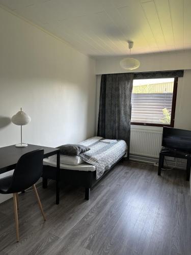 Un dormitorio con una cama y una mesa y una ventana. en Guest House Julia- Cozy Stay in Kajaani, en Kajaani
