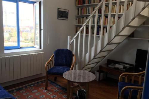 - un salon avec une chaise et un escalier dans l'établissement Charming apartment next to the sea in Trouville, à Trouville-sur-Mer