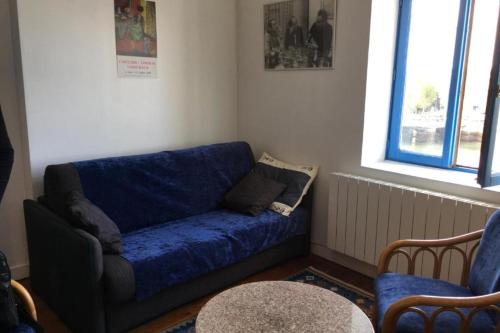 un salon avec un canapé bleu et deux chaises dans l'établissement Charming apartment next to the sea in Trouville, à Trouville-sur-Mer