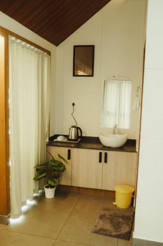 a bathroom with a sink and a mirror at CASA SIGN PRIVATE POOL VILLa in Meppādi