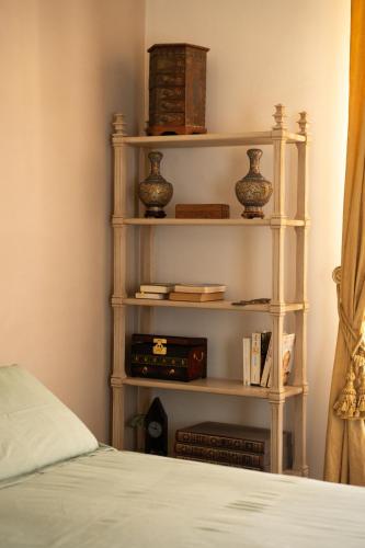 a book shelf with books and vases on it next to a bed at Villa Messori Spa in Castelvetro di Modena