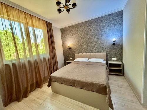 ein Schlafzimmer mit einem Bett und einem großen Fenster in der Unterkunft Apart-hotel RitMati in Tbilisi City