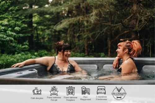 two women in a jacuzzi in a pool at Le2085 - Spa et Plage - Les chalets dans le nord in Sainte-Lucie-de-Doncaster