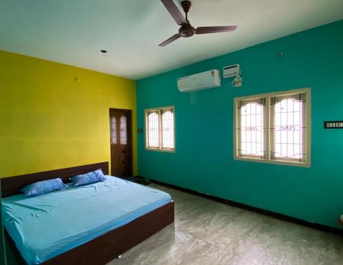 een slaapkamer met groene en gele muren en een bed bij Butterfly Blossom Villa in Samayapuram