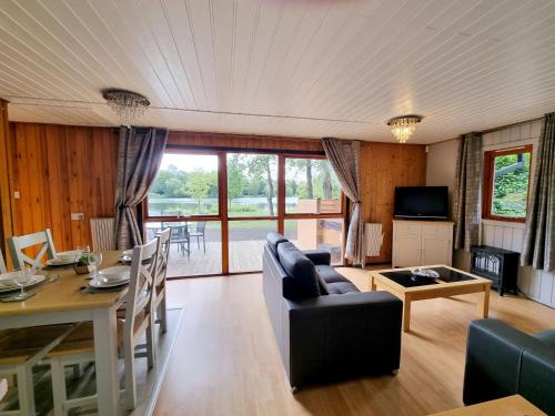 a living room with a table and a dining room at Maple Lodge 11 Hot Tub & Sauna in York