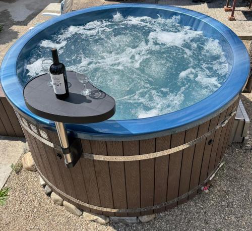 a hot tub with a bottle of wine and a table in it at Casa Ama in Steierdorf