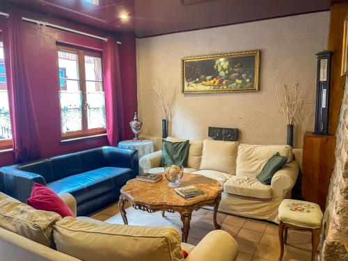 a living room with a blue couch and a table at La Maison Bleue - Historic House in the Heart of Riquewihr in Riquewihr