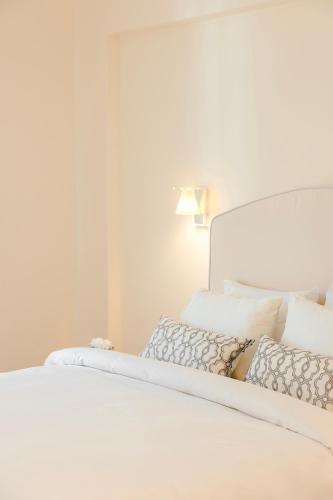 a white bed with white sheets and pillows at Etoile Luxury Suites in Argostoli