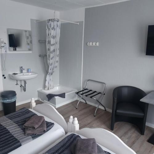 a bedroom with a bed and a sink and a chair at Landgasthof "Hotel zum Norden" in Jagel