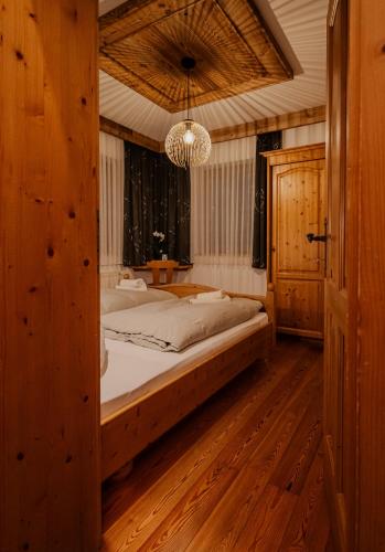 a bedroom with a large bed and a chandelier at Landhaus Gaspar in Wagrain