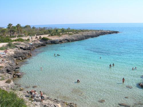 a group of people in the water at a beach at Gma Home Primo Piano in Pulsano