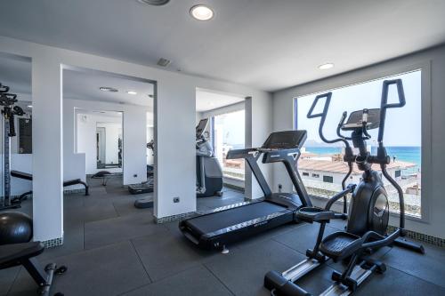a gym with cardio equipment and a view of the ocean at THB Gran Playa - Adults Only in Can Picafort