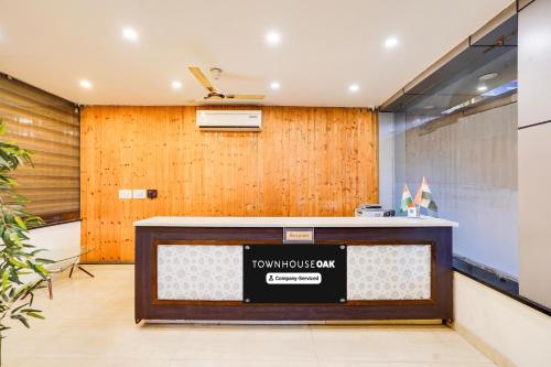 an office with a reception desk in front of a wooden wall at Super Townhouse Oak Silver City Chowk Formerly HW Residency in Dehradun